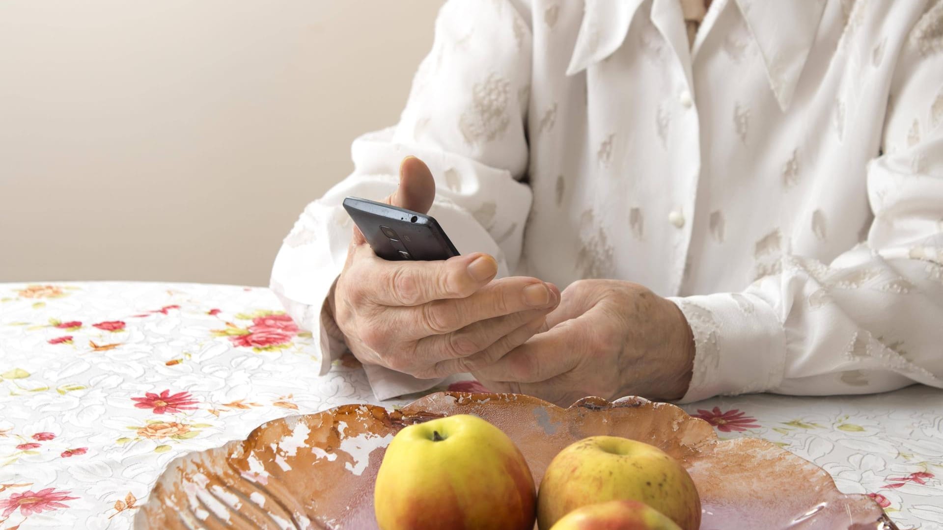 Eine ältere Dame hält ein Telefon in der Hand (Symbolbild): Eine Bande in Berlin hat Senioren um ihr Geld betrogen. Eine ältere Dame hält ein Telefon in der Hand (Symbolbild): Eine Bande in Berlin hat Senioren um ihr Geld betrogen.