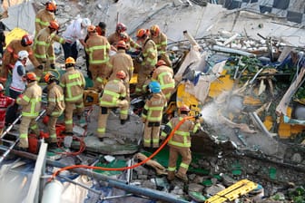 Feuerwehrleute suchen im Wrack des Busses unter den Trümmern nach Überlebenden: Warum das Gebäude unkontrolliert einstürzte, ist bislang nicht bekannt.