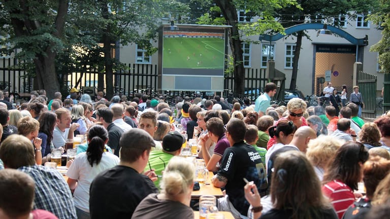 Menschen sehen ein Fußballspiel in einem Biergarten (Archivbild): Dieses Jahr soll es zwar Public Viewing geben – aber mit strengen Regeln.