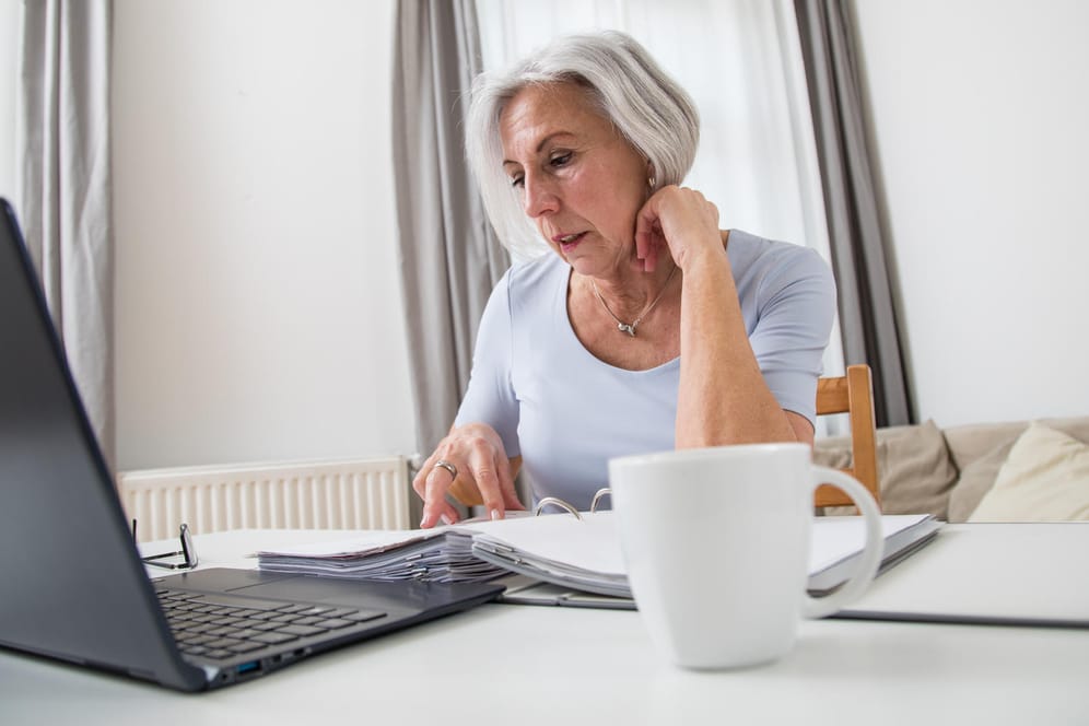 Ältere Frau arbeitet am Laptop (Symbolbild): Millionen Privatanleger könnten Geld zurückbekommen.