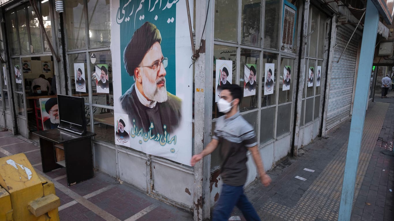 Ein Mann geht in Teheran an einem Wahlplakat von Ebrahim Raisi vorbei: Der konservative Politiker ist Vorsitzender der Justiz der Islamischen Republik.