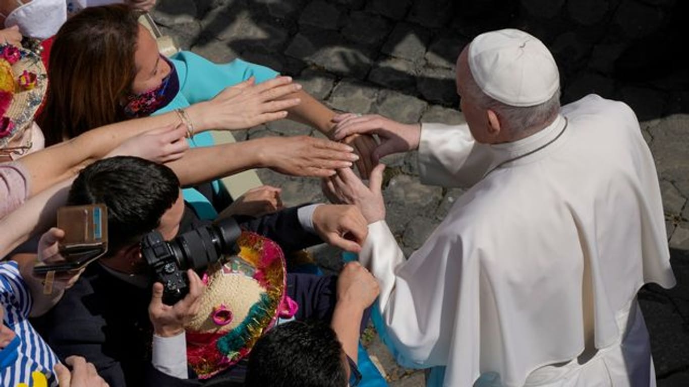 Gläubige strecken ihre Hände aus, um Papst Franziskus zu berühren
