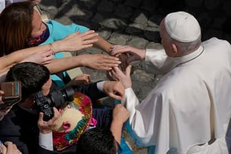 Gläubige strecken ihre Hände aus, um Papst Franziskus zu berühren