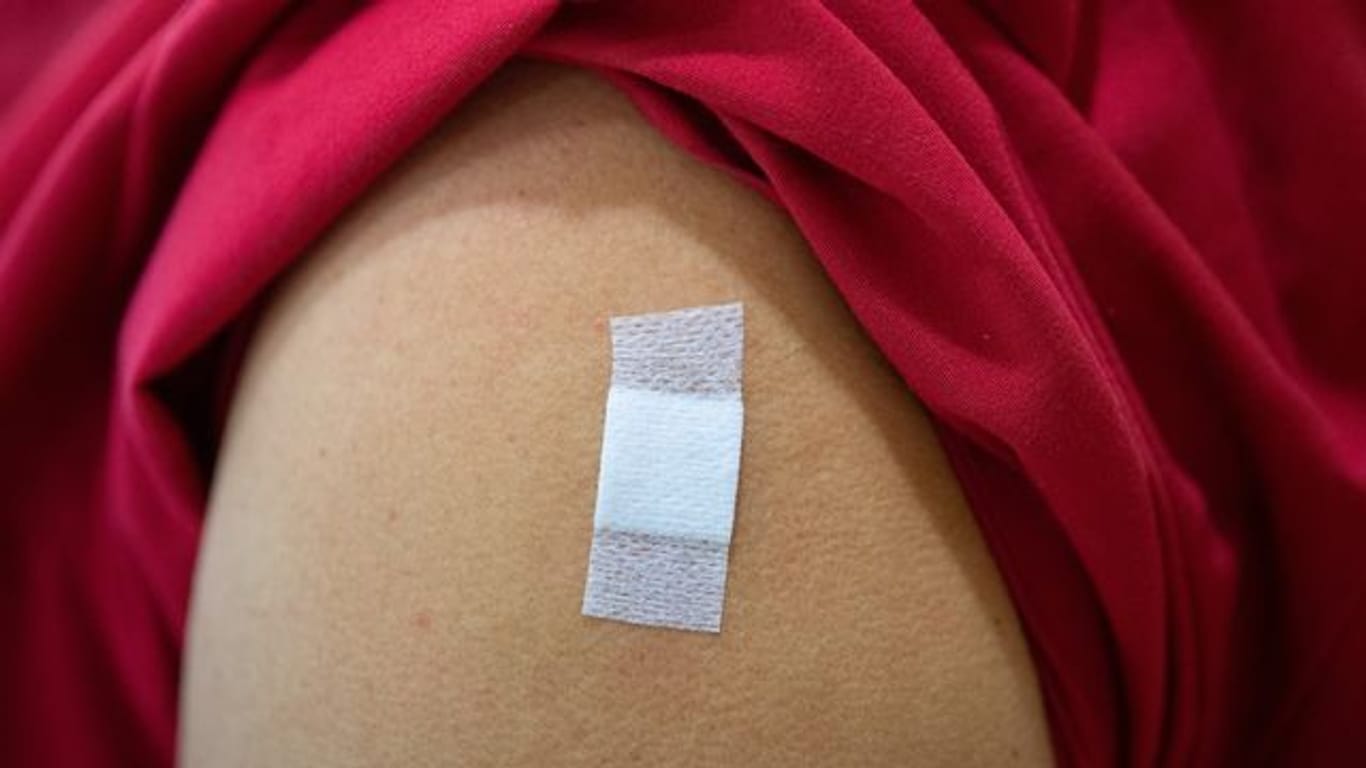 Ein Pflaster klebt auf dem Oberarm nach einer Impfung
