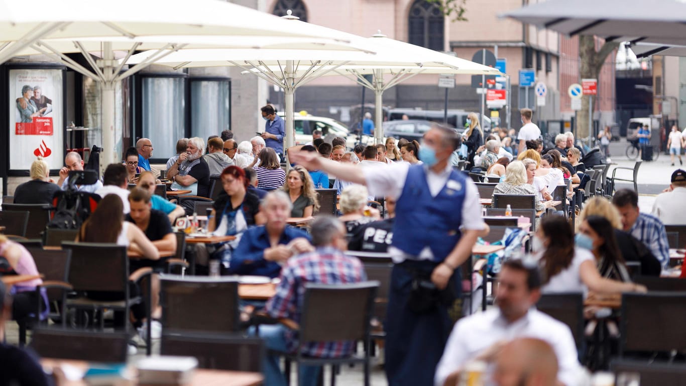 Viele Menschen sitzen in der erst vor kurzem geöffneten Außengastronomie in der Kölner Innenstadt: Der Geschäftsführer des Dehoga Nordrhein spricht sich für einen massiven Preisanstieg in Restaurants und Bars aus.