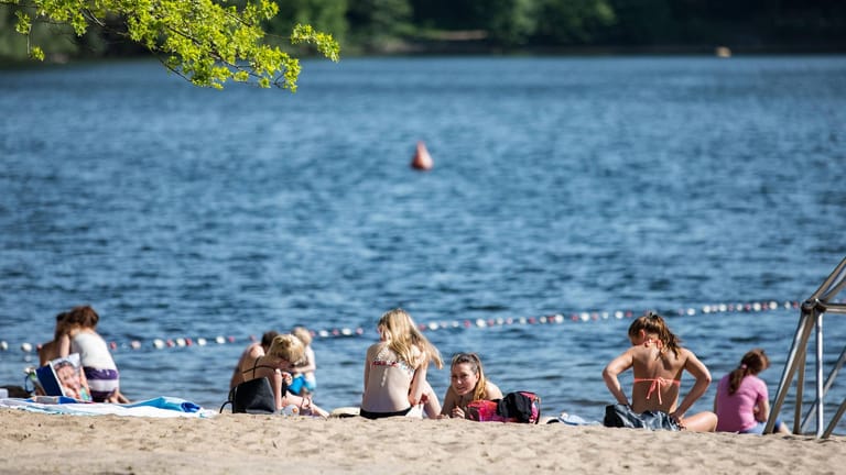 Gäste liegen an einem Badesee (Symbolbild): An einem Kölner Baggersee haben Jugendliche einen 20-Jährigen und einen 19-Jährigen überfallen.