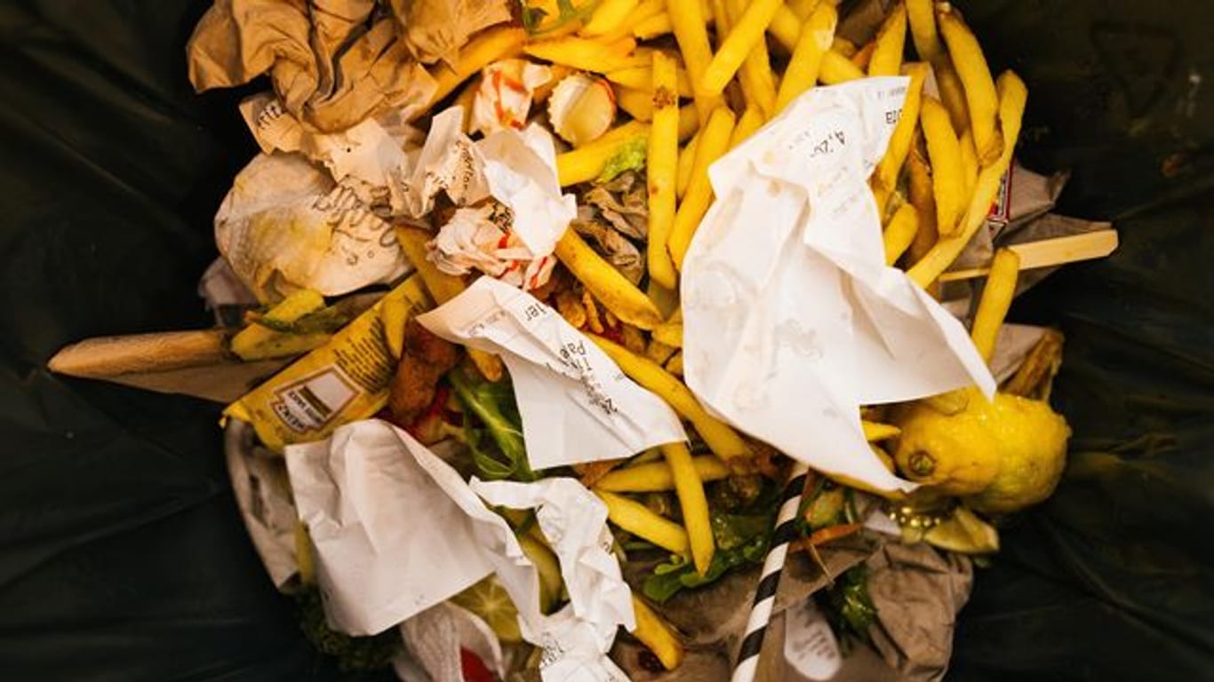 Lebensmittelreste liegen in der Mülltonne eines Restaurants (Archivbild): In den Kantinen Baden-Württembergs soll künftig weniger Müll entstehen.