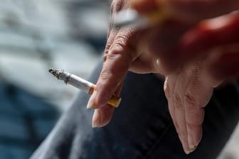 Eine Raucherin hält eine brennende Zigarette in der Hand (Symbolbild): Die Tabaksteuer zieht deutlich an.