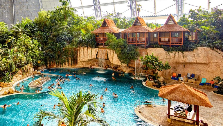 Der Freizeitpark zeigt sich im tropischen Stil mit Holzhütten, exotischen Pflanzen und vielen Schwimmmöglichkeiten.