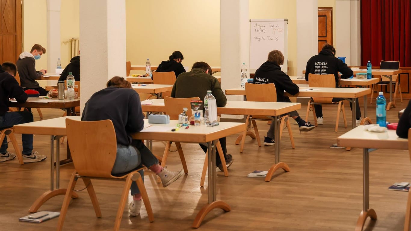 Schüler sitzen in der Aula einer Schule und schreiben ihre Abiturprüfungen (Archivbild): Trotz der Corona-Maßnahmen sind die Prüfungen in Hamburg besser ausgefallen als im Vorjhr.