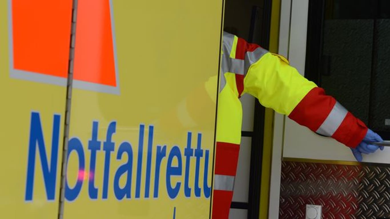 Ein Rettungsassistent steigt in einen Rettungswagen (Symbolbild): Bei einem Unfall in Hamburg ist ein E-Bike-Fahrer lebensgefährlich verletzt worden.