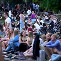 Menschen sitzen am Freitag im Monbijoupark in Berlin-Mitte: Dort musste die Polizei wegen zu vieler Leute im Verlauf des Abends eingreifen.