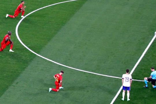 Belgische Spieler und Schiedsrichter Antonio Mateu Lahoz knien vor dem Spiel gegen Russland.