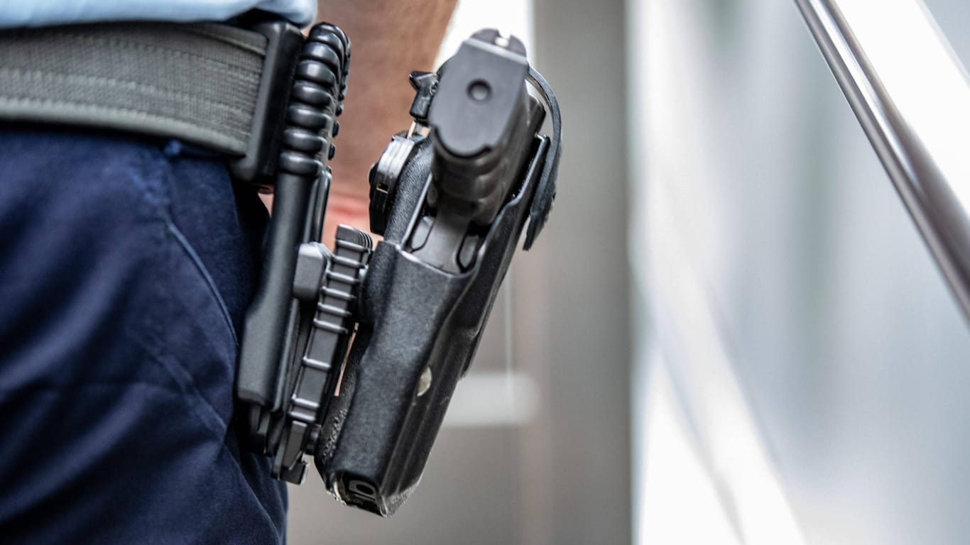 Ein Polizist trägt eine Pistole am Gürtel (Symbolbild): Die Beamten waren zuvor bedroht worden.