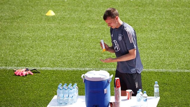 Lukas Klostermann benutzt Sonnencreme vor dem Aufwärmtraining.