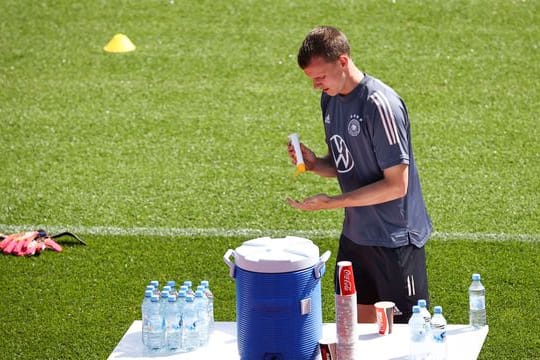 Lukas Klostermann benutzt Sonnencreme vor dem Aufwärmtraining.