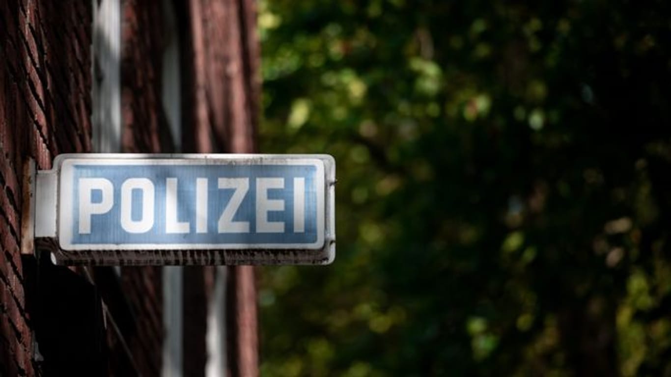 Ein Schild, auf dem "Polizei" steht, hängt an einer Wache (Symbolbild): In München ist ein Mann schwer verletzt aufgefunden worden.