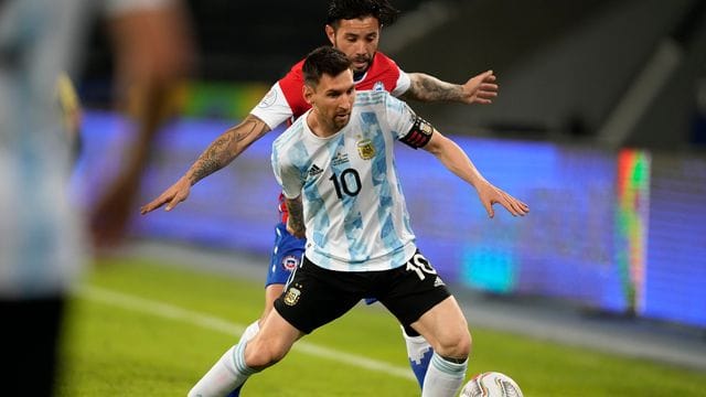 Argentiniens Lionel Messi (vorne) und Chiles Eugenio Mena kämpfen um den Ball.