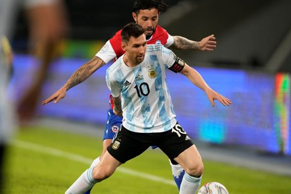 Argentiniens Lionel Messi (vorne) und Chiles Eugenio Mena kämpfen um den Ball.
