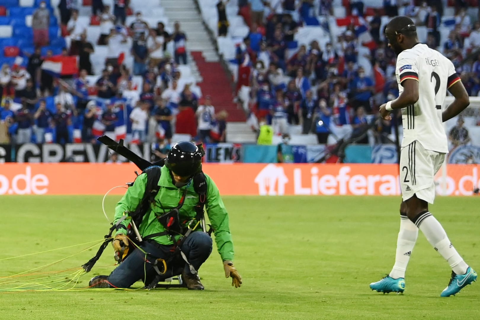 Landung auf dem Feld: Der Fallschirmspringer kommt direkt neben DFB-Verteidiger Antonio Rüdiger auf.