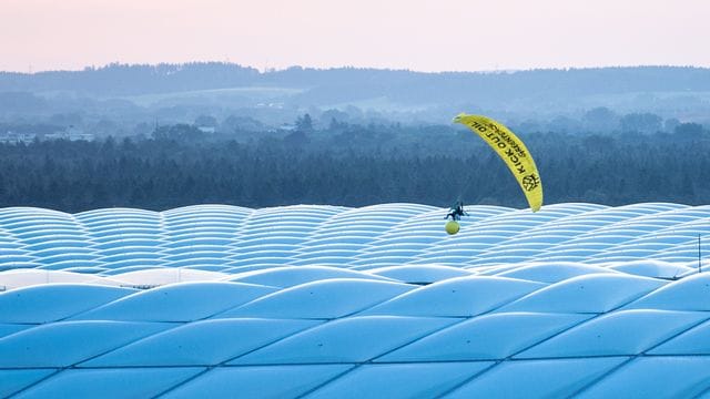 Ein Aktivist von Greenpeace landet mit einem Gleitschirm im Stadion.