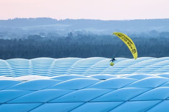 Ein Aktivist von Greenpeace landet mit einem Gleitschirm im Stadion.