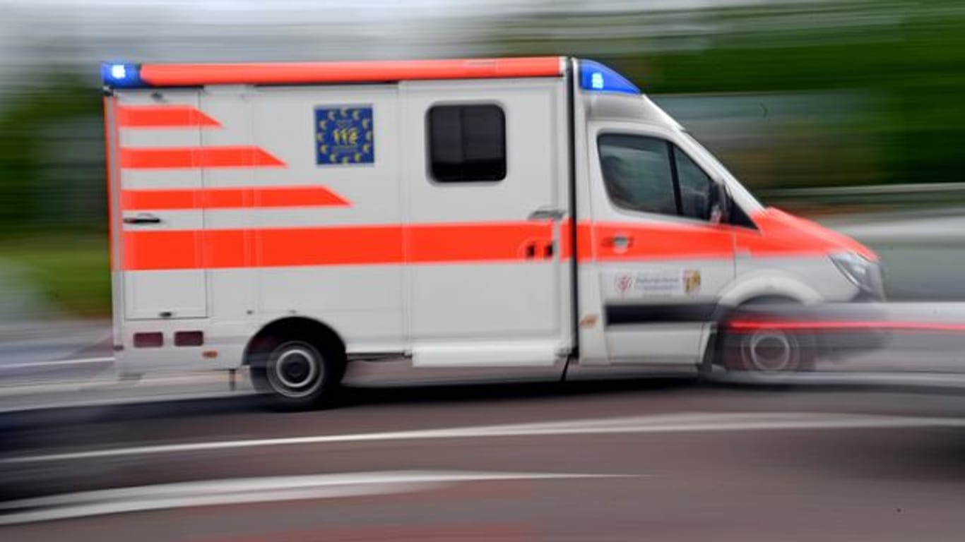 Ein Krankenwagen fährt mit Blaulicht auf einer Straße