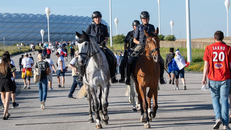 Polizeibeamte der Reiterstaffel patroullieren vor dem Stadion durch die ankommenden Fans: Die Polizei war mit dem Einsatz zufrieden.
