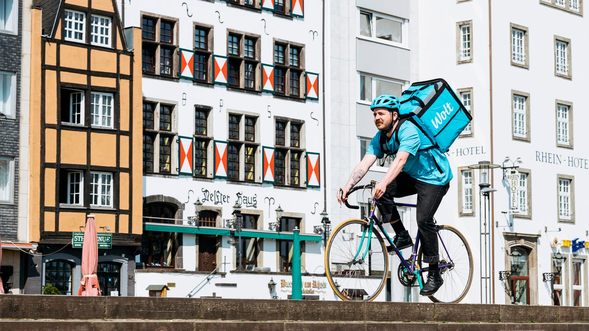 Ein Kurierfahrer von Wolt fährt durch Köln: Ab sofort wird es auf den Straßen der Rheinmetropole noch etwas bunter. Ein Kurierfahrer von Wolt fährt durch Köln: Ab sofort wird es auf den Straßen der Rheinmetropole noch etwas bunter.