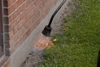 Ein Gärtner verbrennt Unkraut (Symbolbild): An heißen und trockenen Tagen kann sich das Feuer schnell ungewünscht ausbreiten.