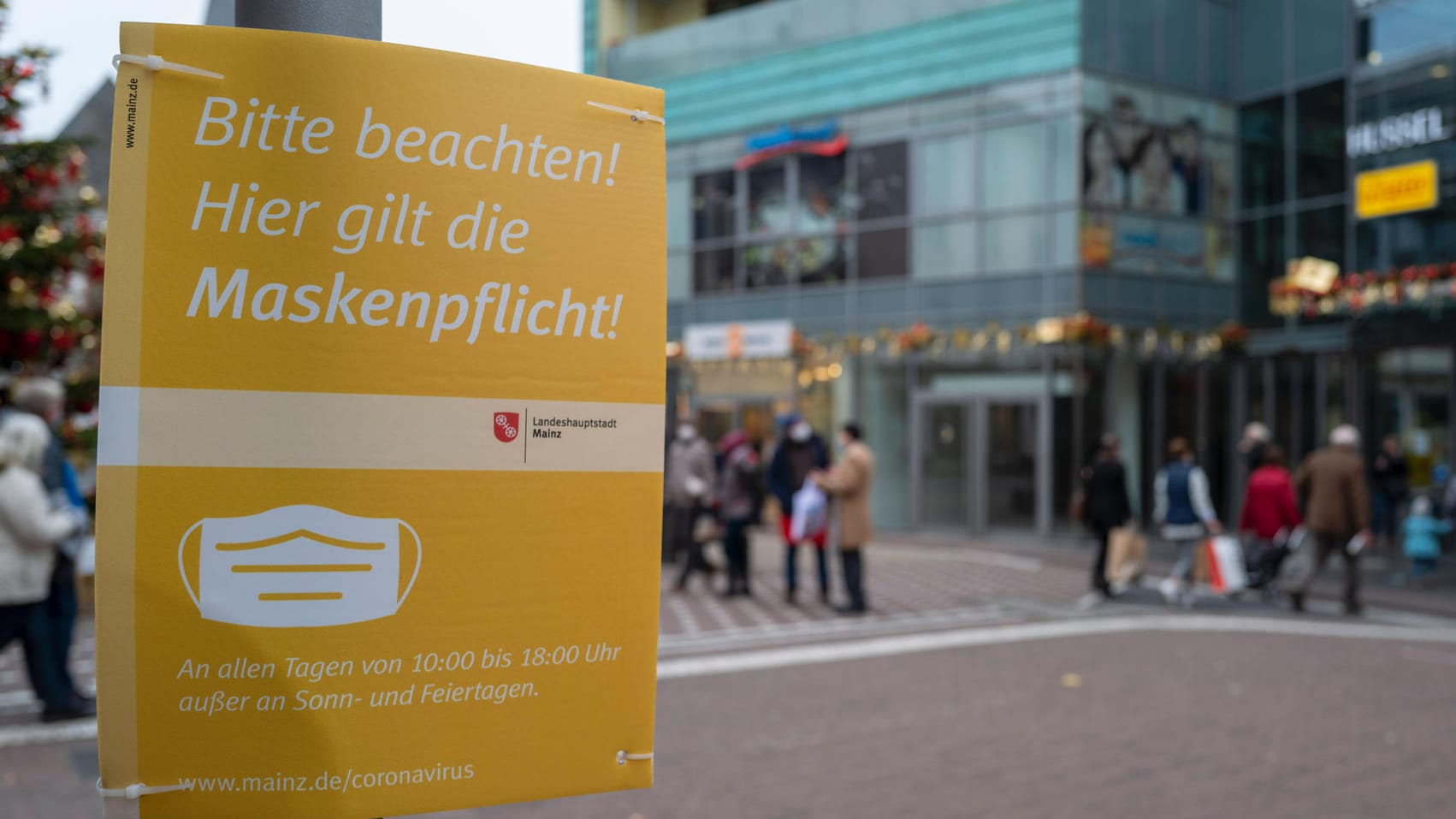 Ein Schild weist auf die damals bestehende Maskenpflicht in Mainz hin (Archivbild): In der Innenstadt von Mainz gilt diese Corona-Regel nun nicht mehr.