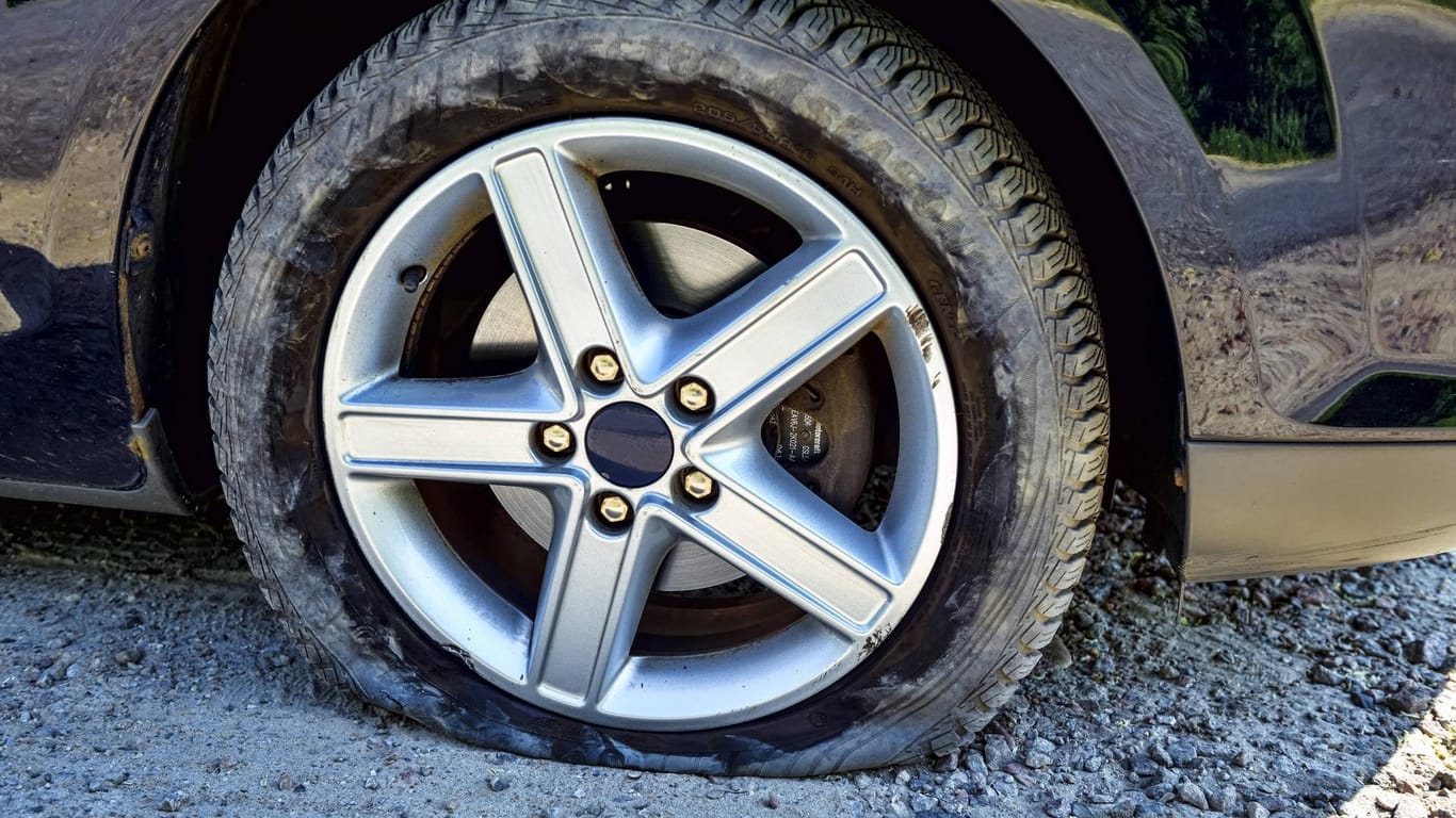 Ein platter Reifen an einem Auto (Symbolbild): In Solingen haben Unbekannte die Reifen mehrerer Pkw zerstochen.
