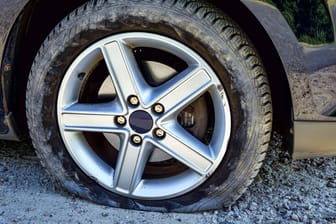 Ein platter Reifen an einem Auto (Symbolbild): In Solingen haben Unbekannte die Reifen mehrerer Pkw zerstochen.