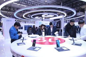Besucher schauen neue Smartphones mit 5G-Technologie an.