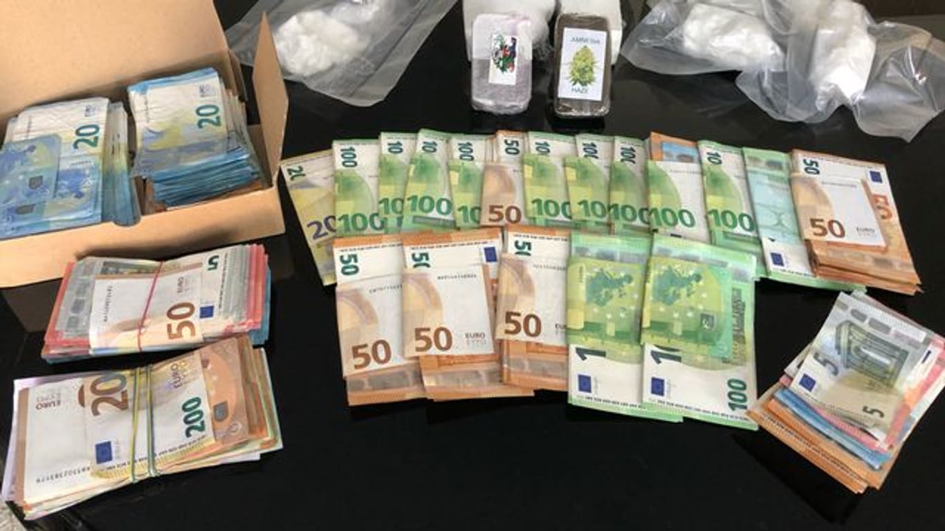 Sichergestelltes Bargeld und Drogen liegen auf einem Tisch im Bonner Polizeipräsidium: Beamte haben vier Verdächtige festgenommen.