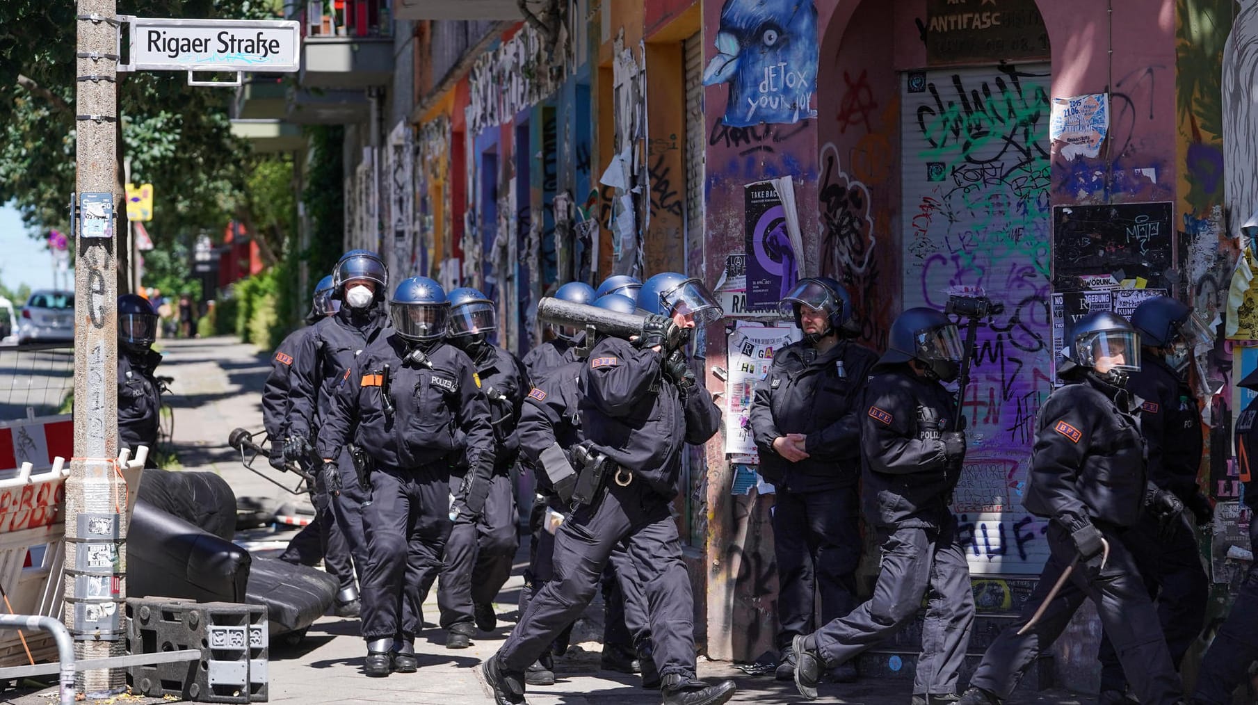 Polizisten gehen in der Rigaer Straße in Berlin-Friedrichshain mit einem Rammbock neben einer Barrikade entlang: Dutzende von ihnen wurden bei der Randale verletzt.