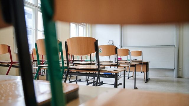 In einem Klassenzimmer des stehen Stühle auf den Tischen (Symbobild): 600 der ausgeschriebenen Stellen konnten bisher nicht besetzt werden.