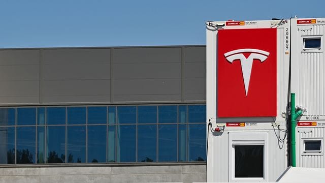 Das Logo von Tesla hängt an einem Container auf der Baustelle der Gigafactory (Archivbild): Aktuell laufen dort Funktionstests.