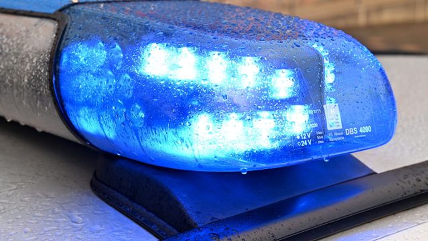 Ein Streifenwagen der Polizei steht mit eingeschaltetem Blaulicht an einem Einsatzort (Symbolbild): Auch ein Polizist wurde bei dem Einsatz durch sein eigenes Reizgas verletzt.