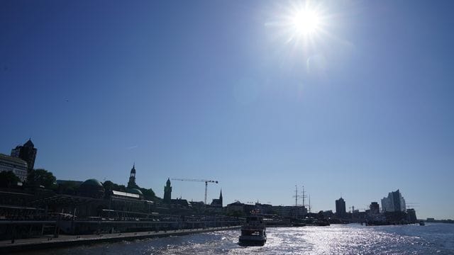 Fähren verlassen bei strahlend blauem Himmel die Landungsbrücken