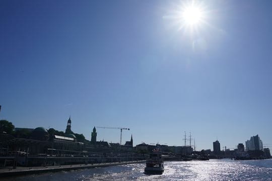 Fähren verlassen bei strahlend blauem Himmel die Landungsbrücken