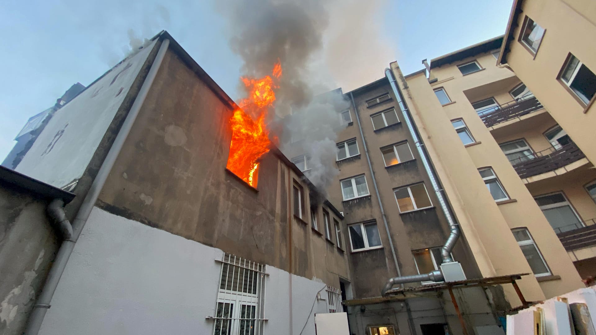Der Einsatzort: Die Flammen schlagen aus dem Anbau eines Mehrfamilienhauses. Der Einsatzort: Die Flammen schlagen aus dem Anbau eines Mehrfamilienhauses.