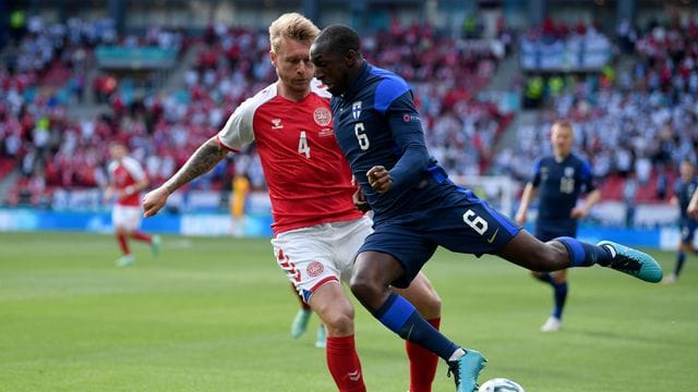 Dänemarks Kapitän Simon Kjaer (l) kämpft mit Finnlands Glen Kamara um den Ball.