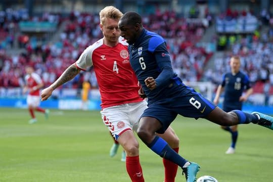 Dänemarks Kapitän Simon Kjaer (l) kämpft mit Finnlands Glen Kamara um den Ball.