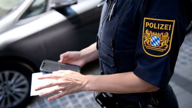 Eine Polizistin stellt einen digitalen Strafzettel aus