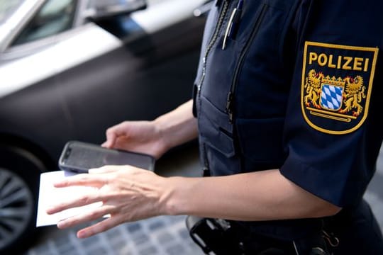 Eine Polizistin stellt einen digitalen Strafzettel aus