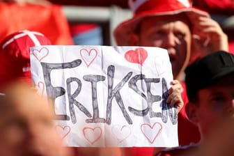 Ein dänischer Fan hebt ein Plakat für den dänischen Spieler Eriksen.