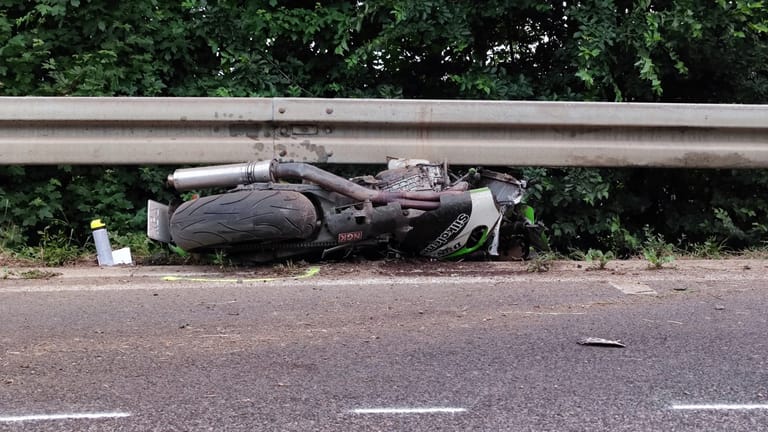 Das Motorrad eines der Verunfallten ist unter einer Leitplanke engeklemmt. Nach dem anderen Fahrer wird noch gefahndet.