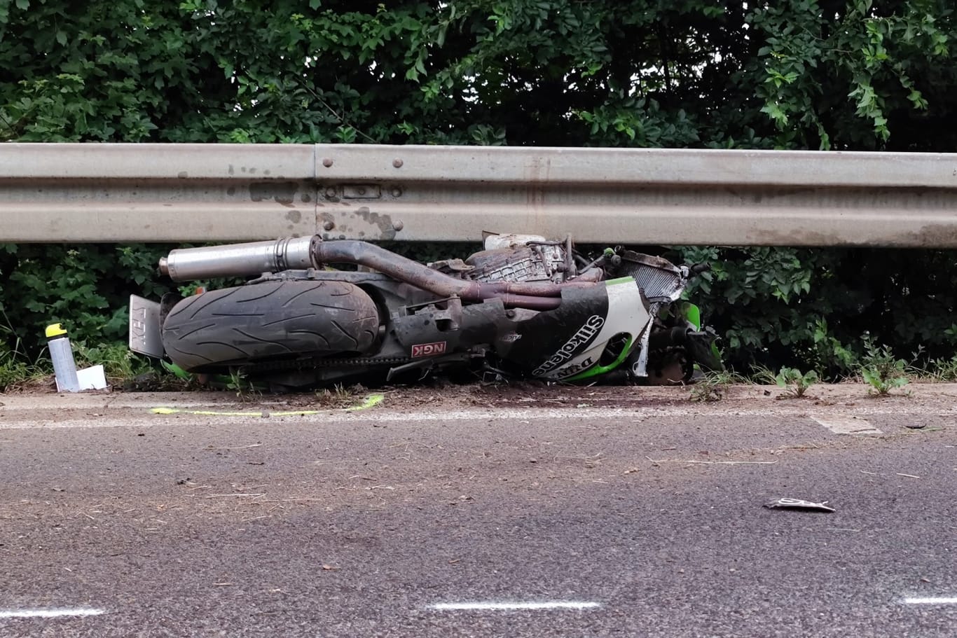 Das Motorrad eines der Verunfallten ist unter einer Leitplanke engeklemmt. Nach dem anderen Fahrer wird noch gefahndet.