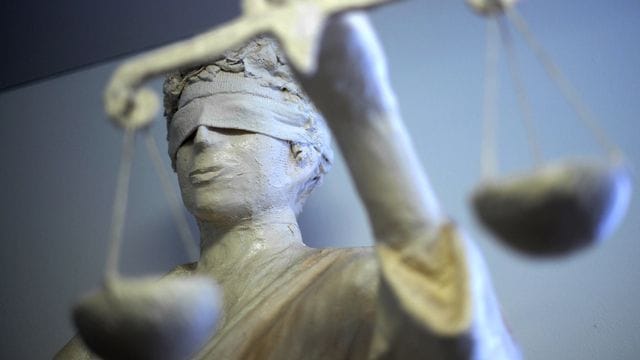 Eine Statue der Justitia hält die Waage